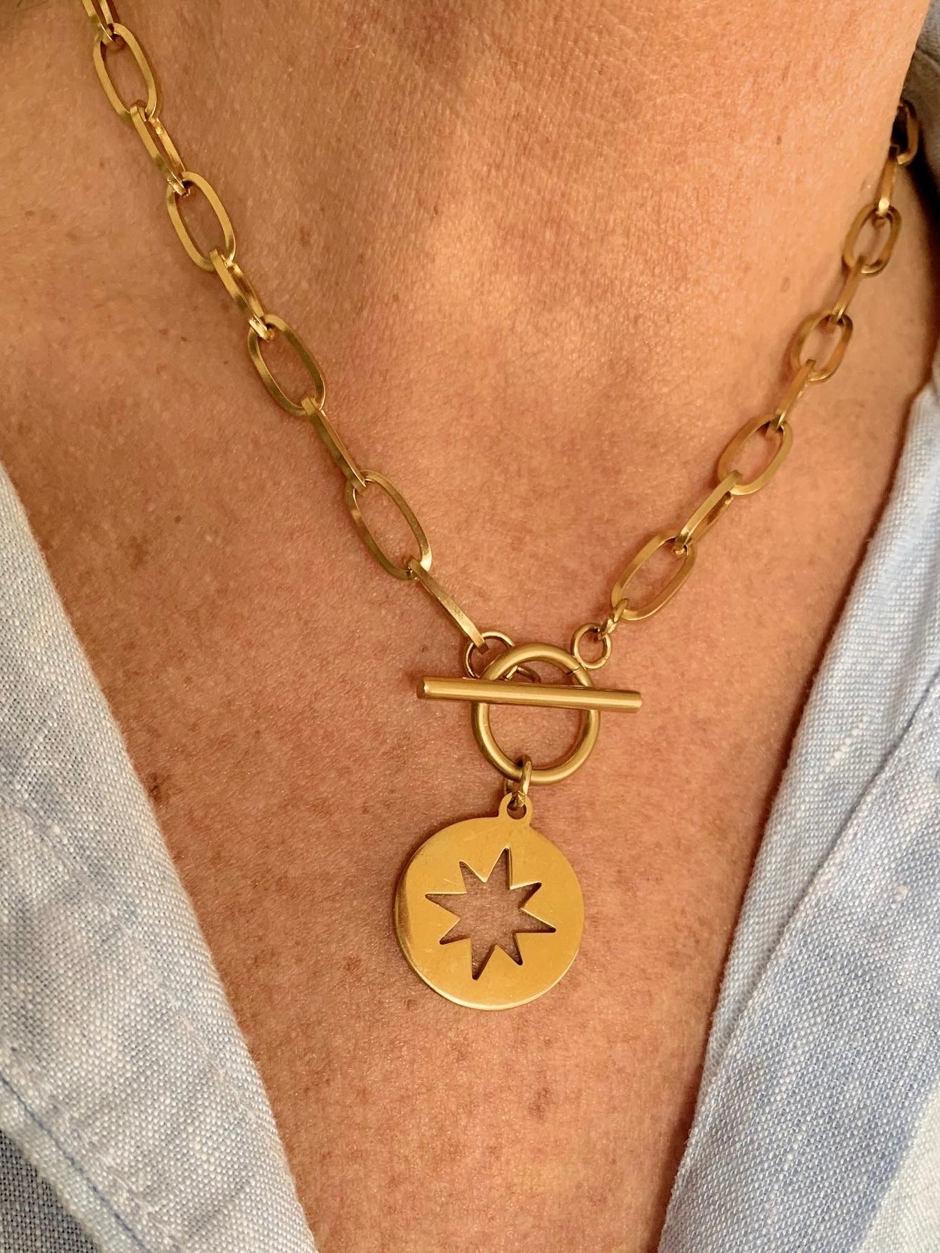 Collar con estrella de 8 puntas huecas doradas y cierre ancla