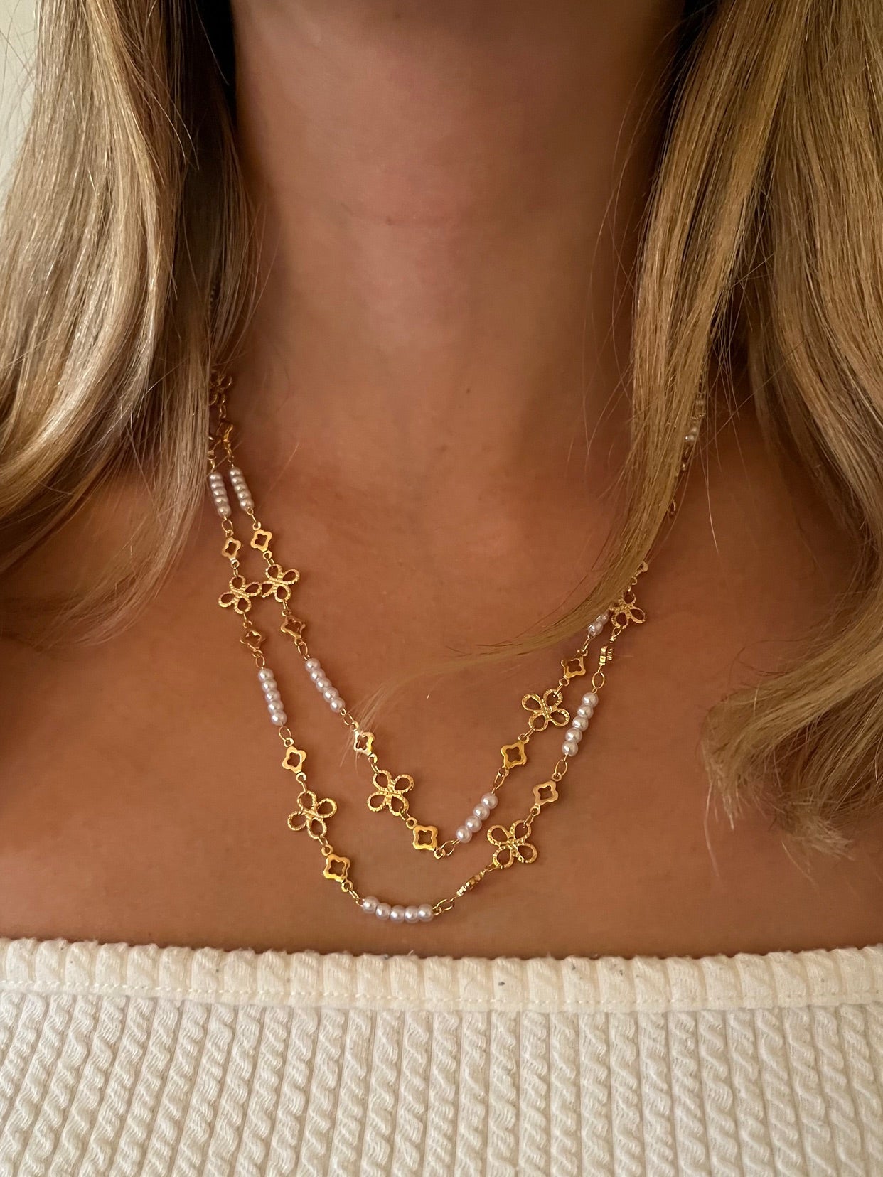 Collar con perlitas blancas y cadena dorada con diseño.